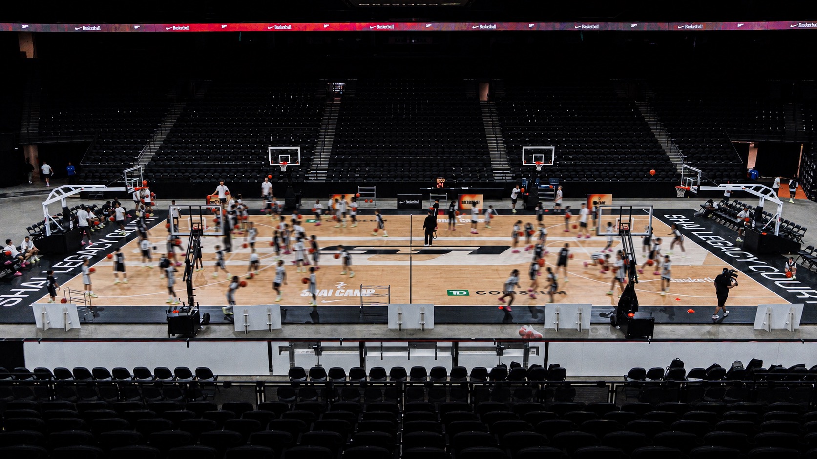 Young athletes practicing on a full basketball court at SGA Camp